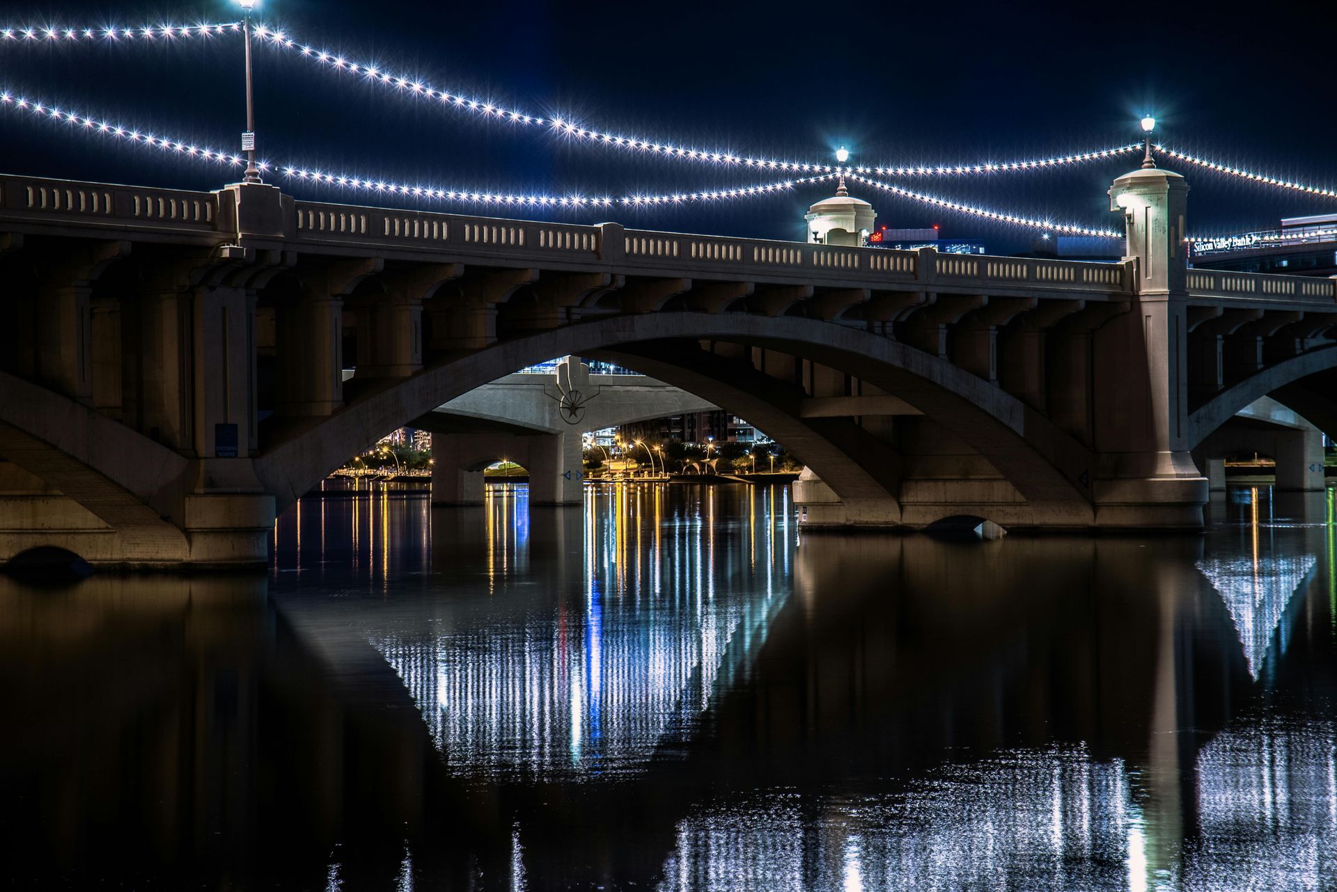 Mill Avenue bridges over Tempe Town Lake at night where Tempe drivers compare car insurance options.