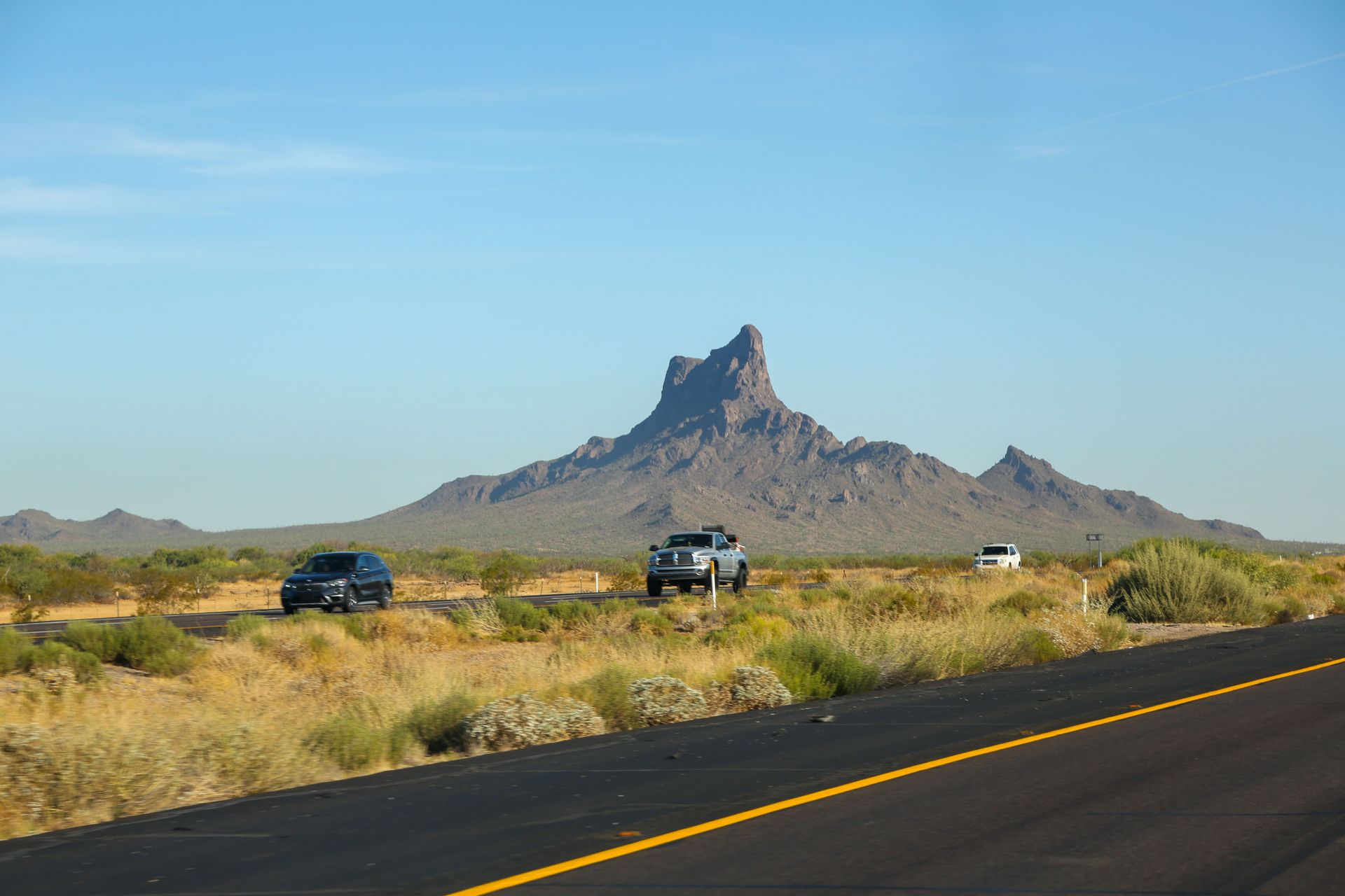 Cars driving an Arizona desert highway, illustrating AmShield car insurance coverage for AZ drivers