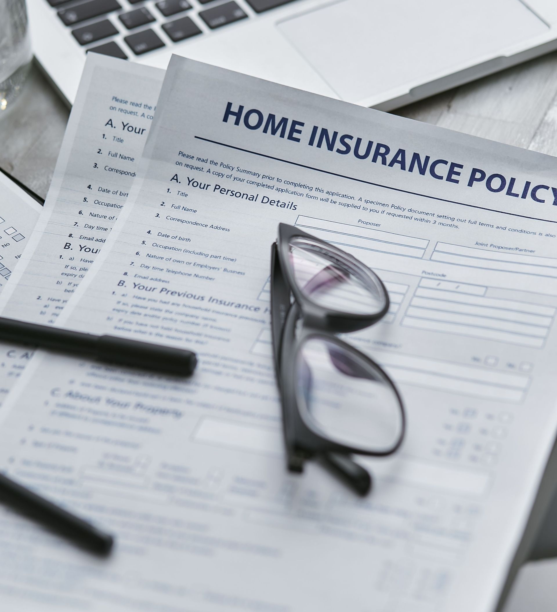 Arizona home insurance policy and reading glasses, showing endorsement and policy rider pages.