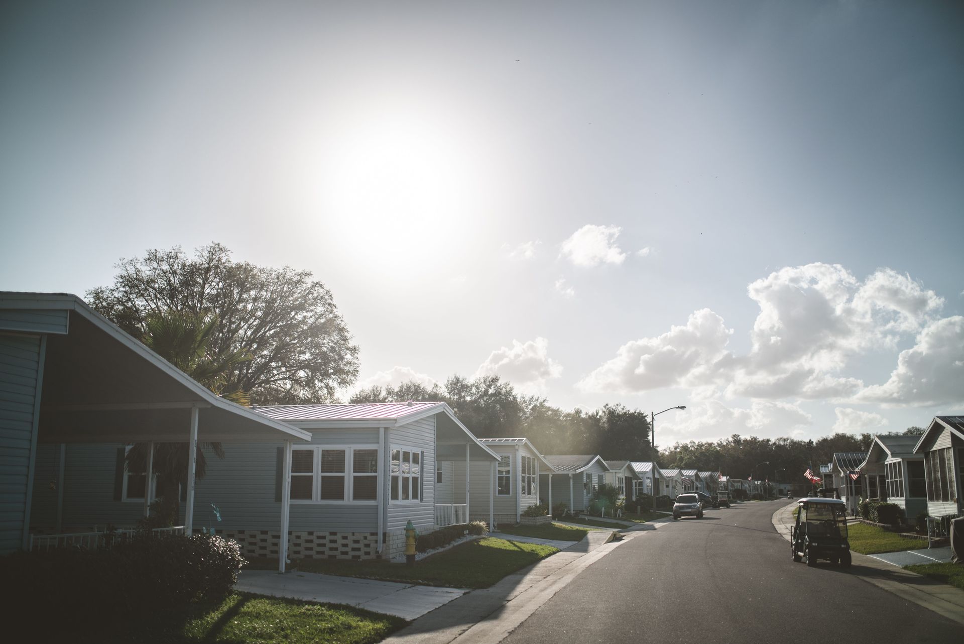 Street view of a manufactured home community in Arizona with paved streets and tidy mobile homes