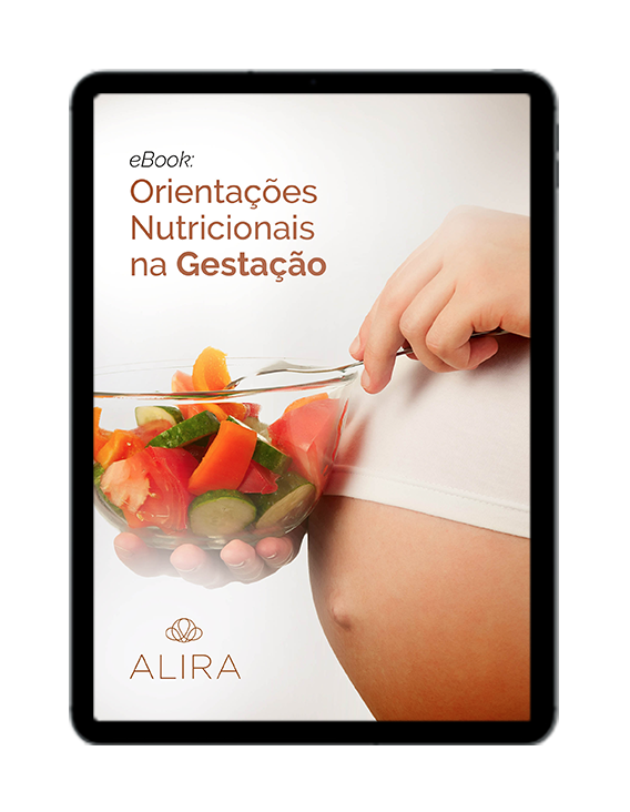 Uma mulher grávida está segurando uma tigela de frutas e vegetais.