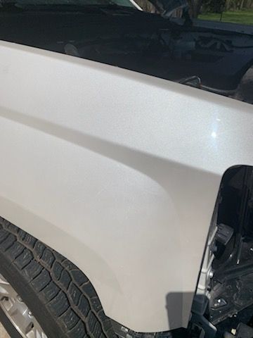 A close up of the fender of a white truck.