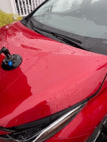 A red car with a suction cup on the hood.