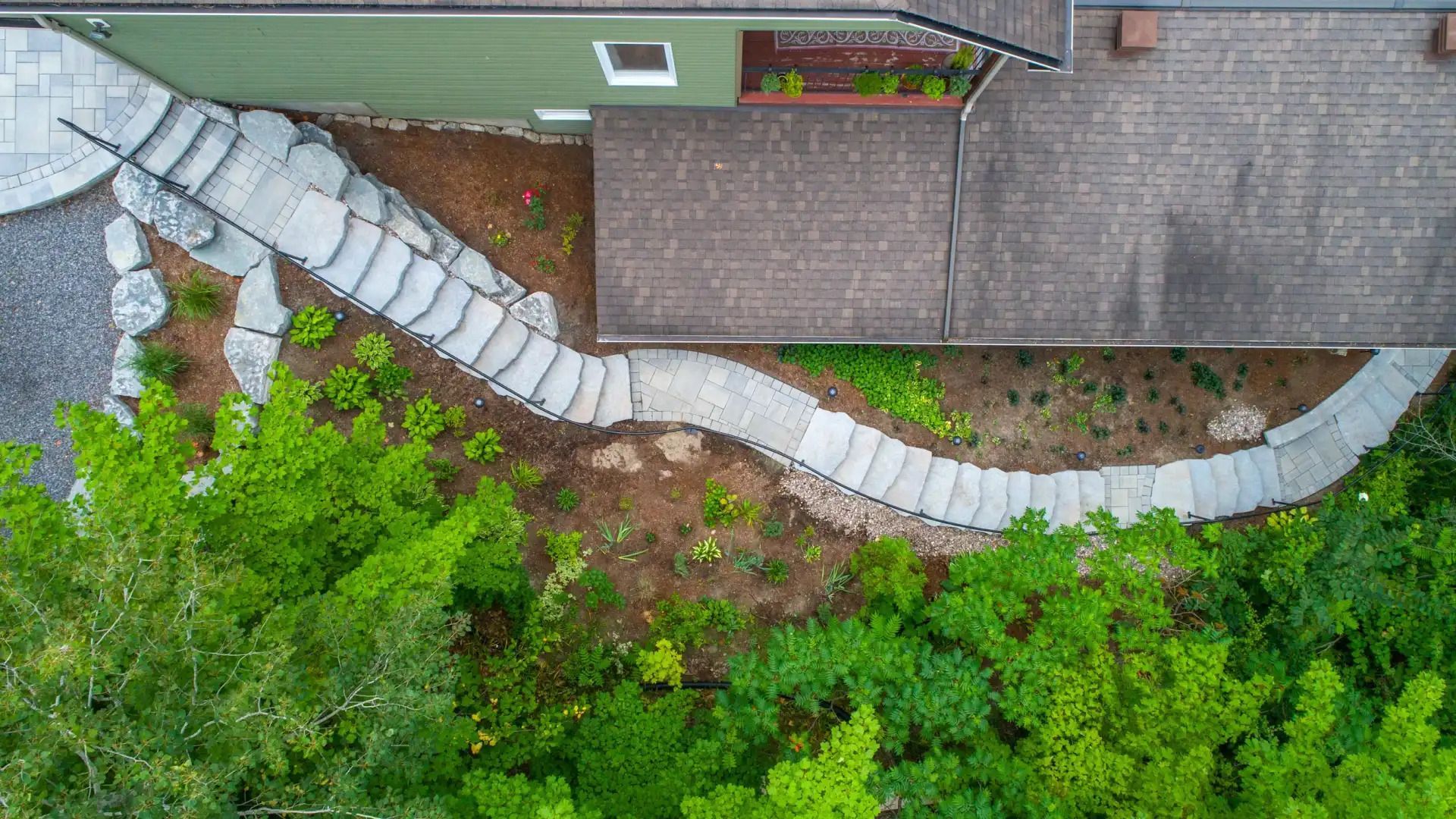 Overhead view of a house with stone stairs winding through a garden.