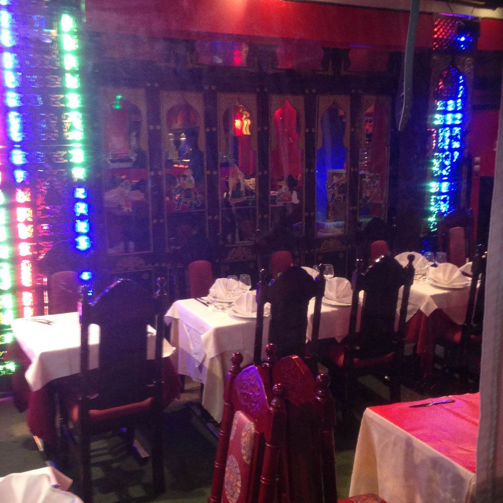 Un restaurant rempli de tables et de chaises avec une nappe rouge