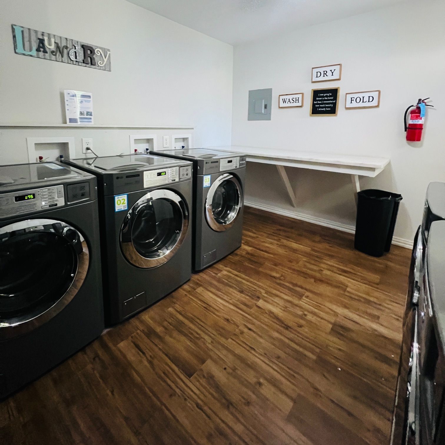 A laundry room with a lot of washers and dryers.