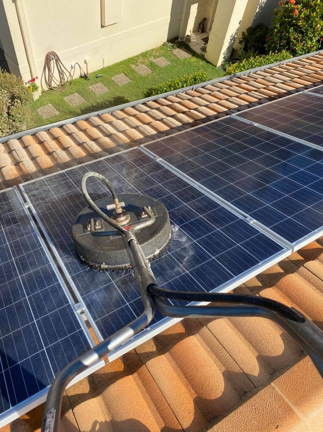 Solar Panels Being Cleaned With a Rotating Surface Cleaner on a Tiled Roof — SEQ Roofing & Painting in Pacific Pines, QLD