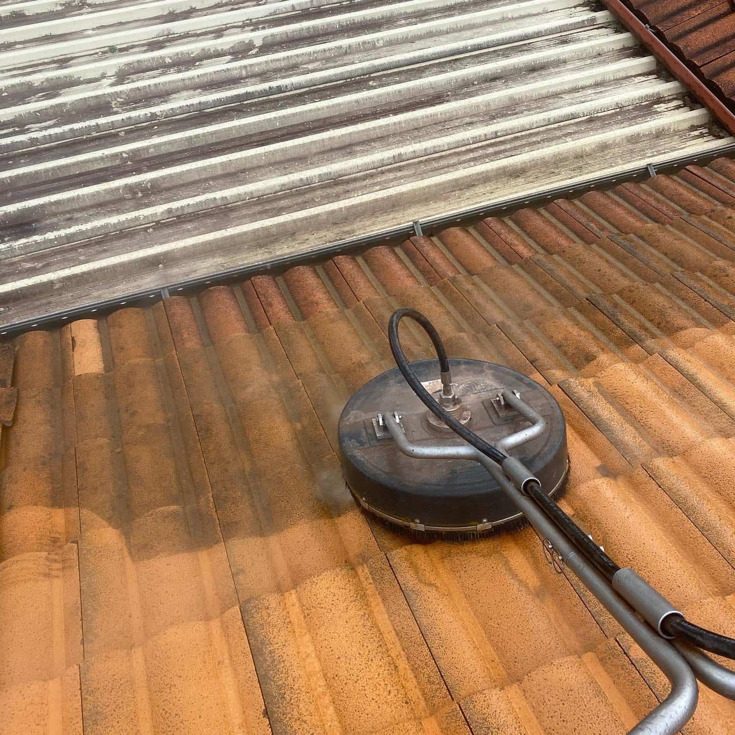 Pressure washer cleaning a red tile roof. — SEQ Roof Repaints In Bonogin, QLD