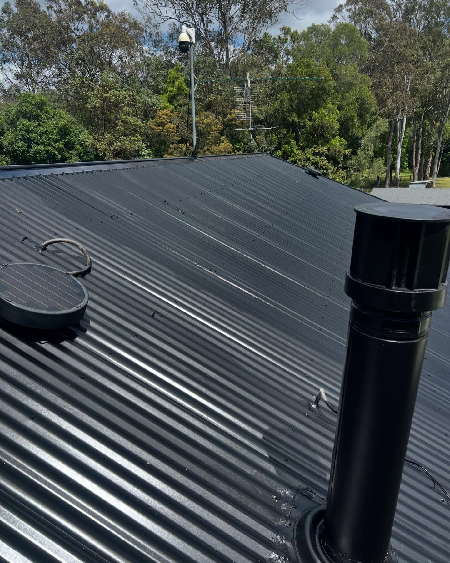 Black Corrugated Metal Roof With Vent Pipe — SEQ Roofing & Painting in Nerang, QLD