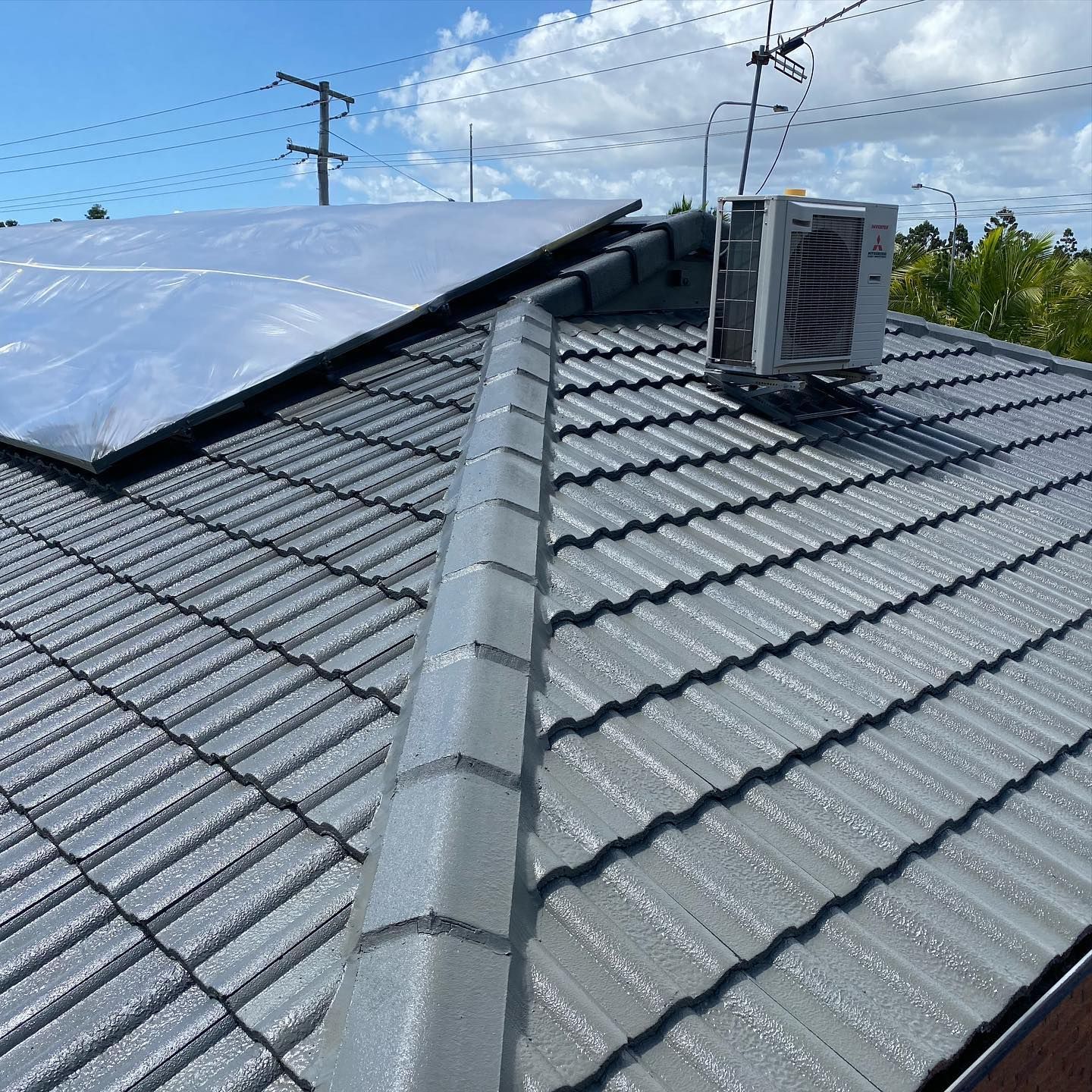 Gray Tiled Roof with Solar Panels and An Air Conditioning — SEQ Roof Repaints In Logan, QLD