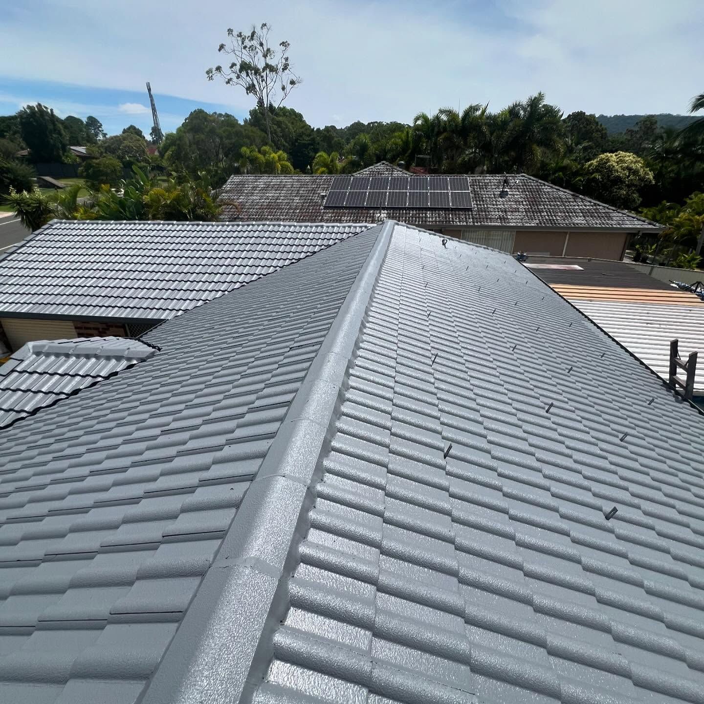 Gray Tiled Roof on A House, with Trees and Another House — SEQ Roof Repaints In Tweed Heads, NSW
