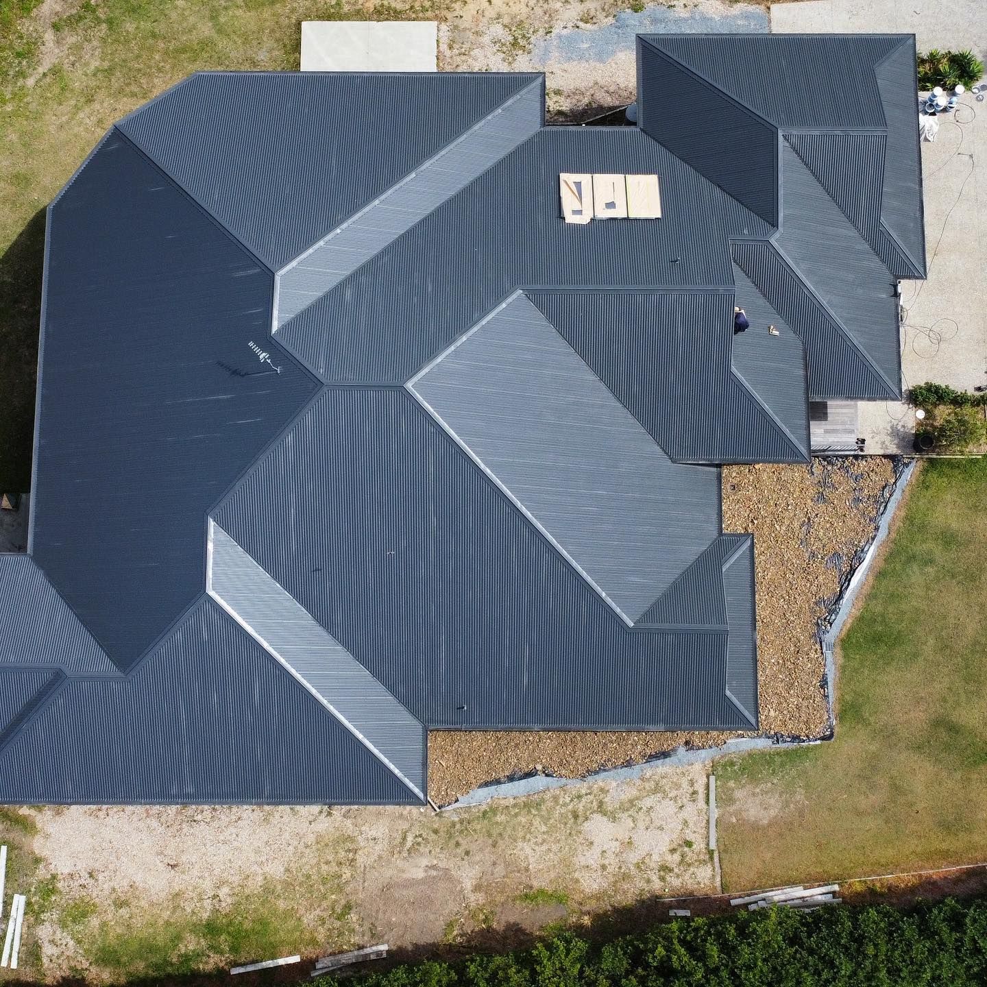 Overhead View of a House With a Complex, Dark Gray Metal Roof Under Construction — SEQ Roofing & Painting in Nerang, QLD