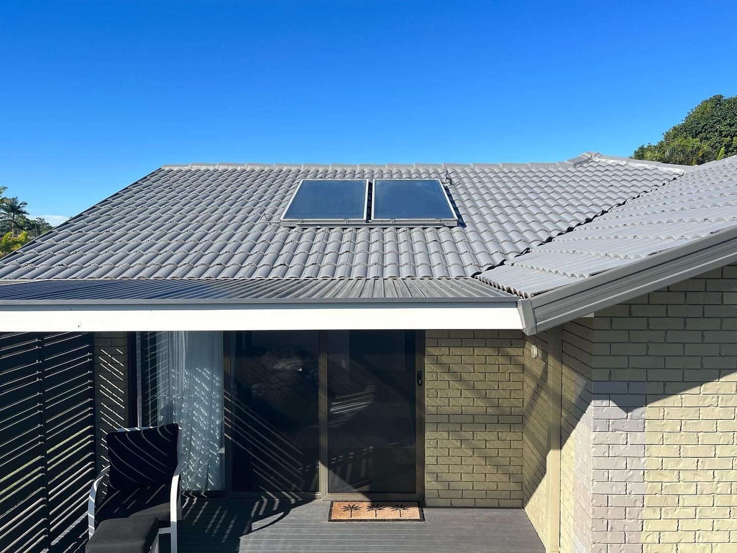 Gray Tile Roof With Two Solar Panels — SEQ Roofing & Painting in Mermaid Waters, QLD