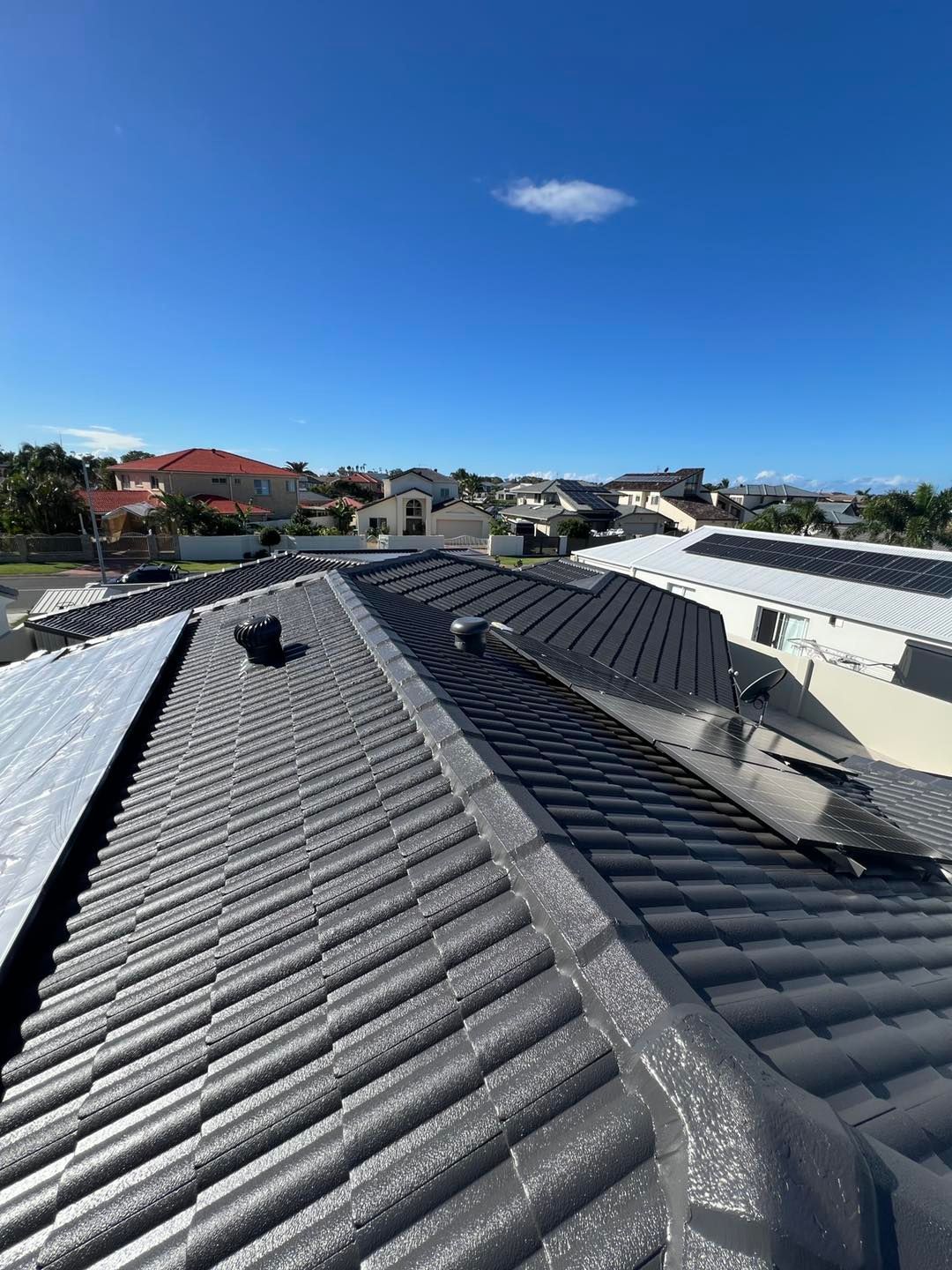 View from A Rooftop: Grey Tiled Roof with Vents, Sunny Day — SEQ Roof Repaints In Tweed Heads, QLD
