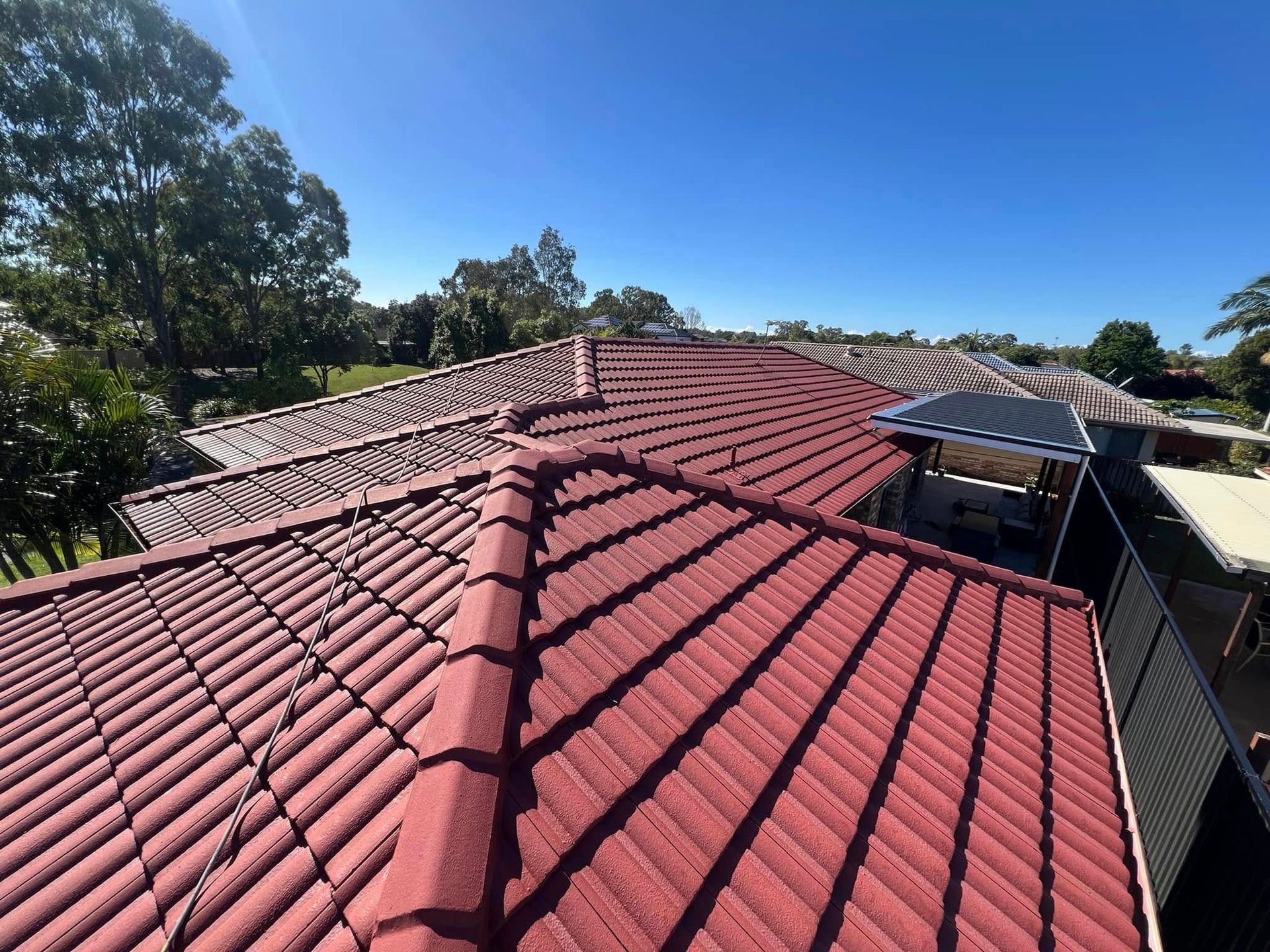 Red Tile Roof on A Sunny Day with Clear Blue Sky — SEQ Roof Repaints In Bonogin, QLD