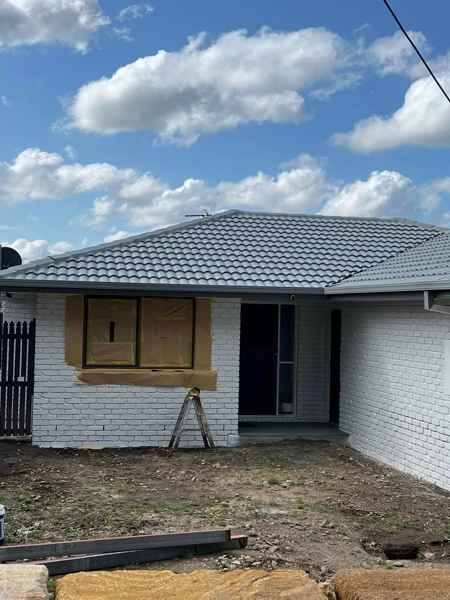 White Brick House With Gray Roof, Construction in Progress — SEQ Roofing & Painting in Nerang, QLD