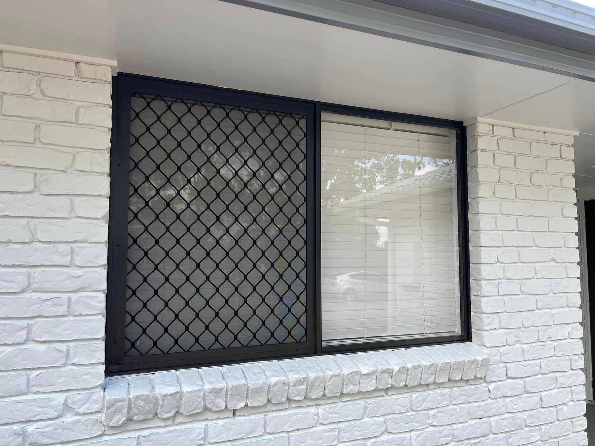 Black-framed Window With Security Screen and Closed Blinds — SEQ Roofing & Painting in Nerang, QLD