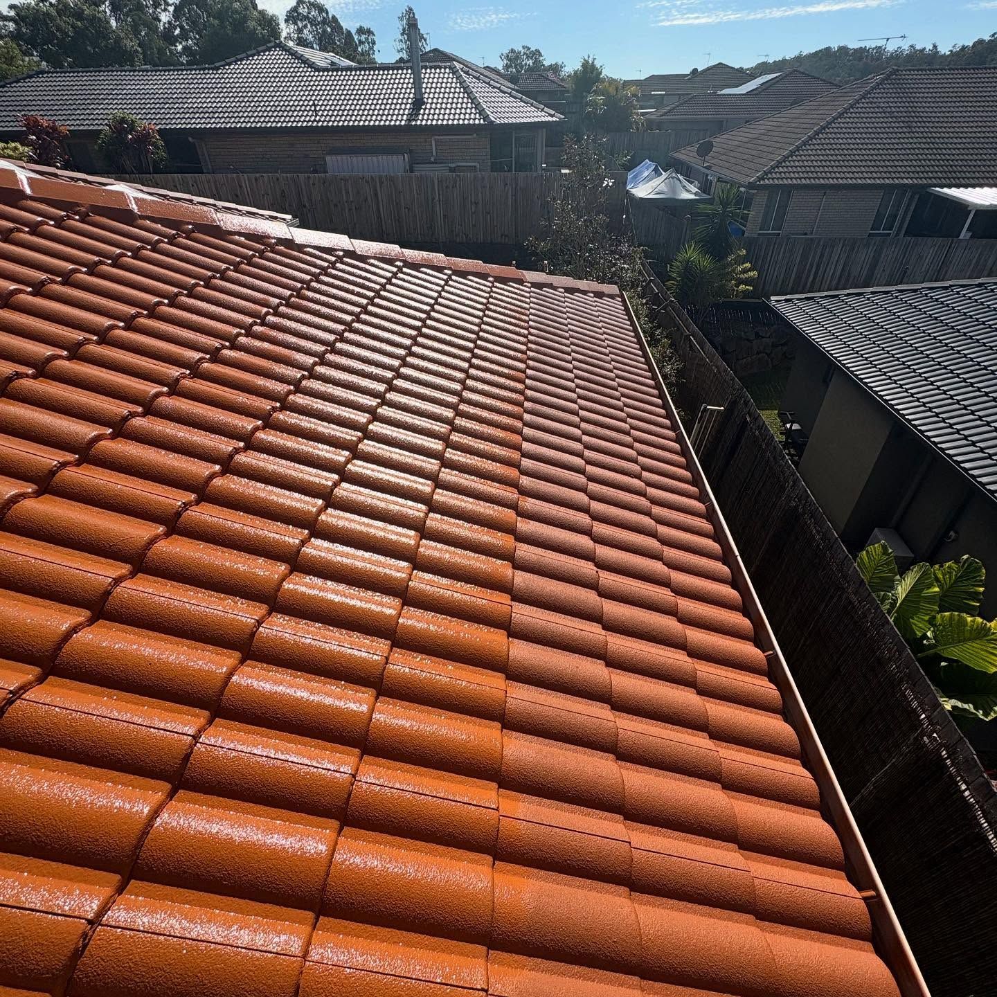 Orange Tiled Roof, with Gutter in Foreground and Suburban Houses — SEQ Roof Repaints In Nerang, QLD