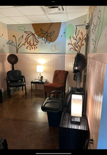 Hair salon with hooded dryers, chairs, and doorway to another room.