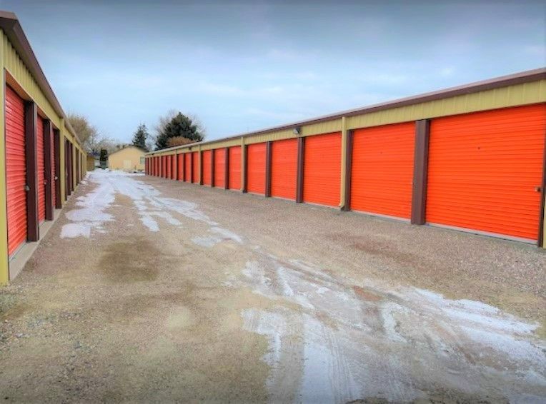 A row of orange storage units with snow on the ground