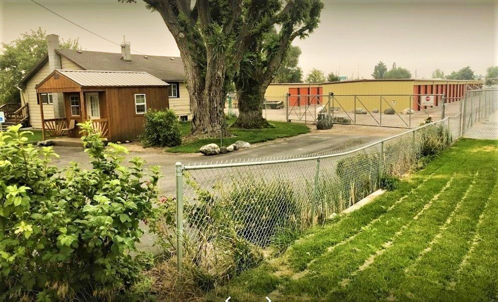 A chain link fence surrounds a house and a storage facility