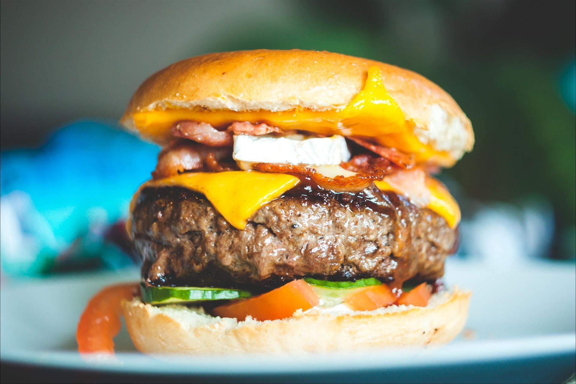 A close up of a hamburger on a white plate.