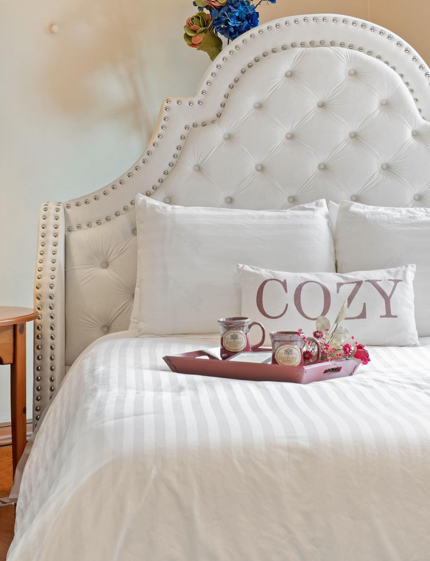 A bed with a pillow that says cozy on it