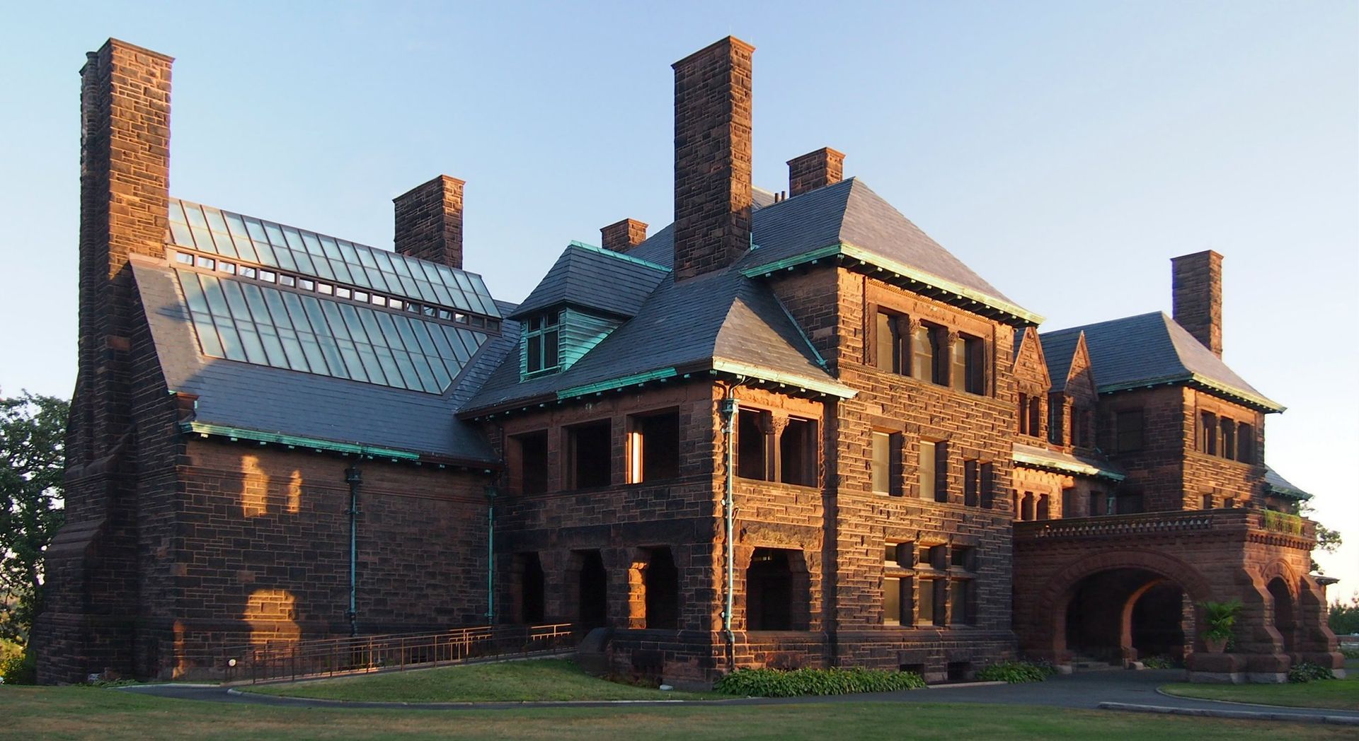 A large brick building with a metal roof and chimneys