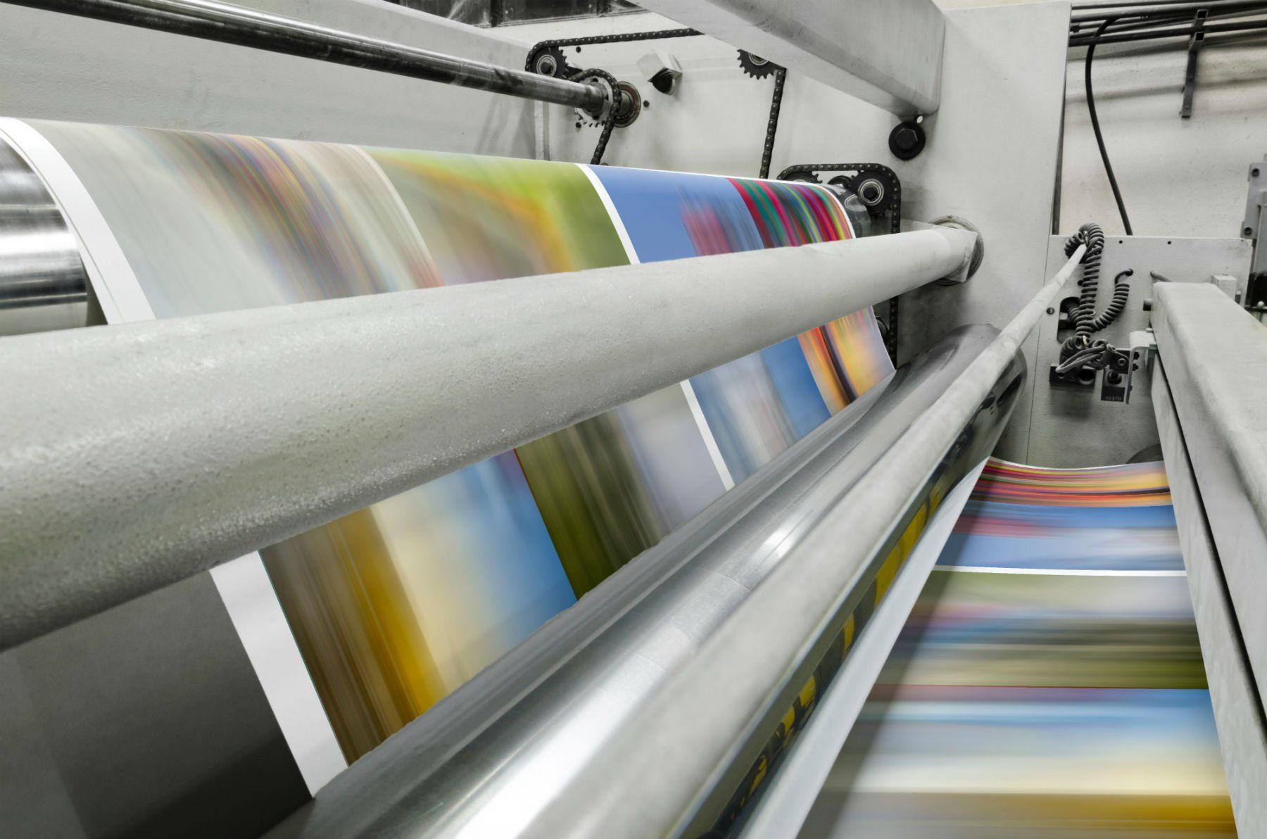 Una macchina da stampa sta stampando un sacco di carte colorate
