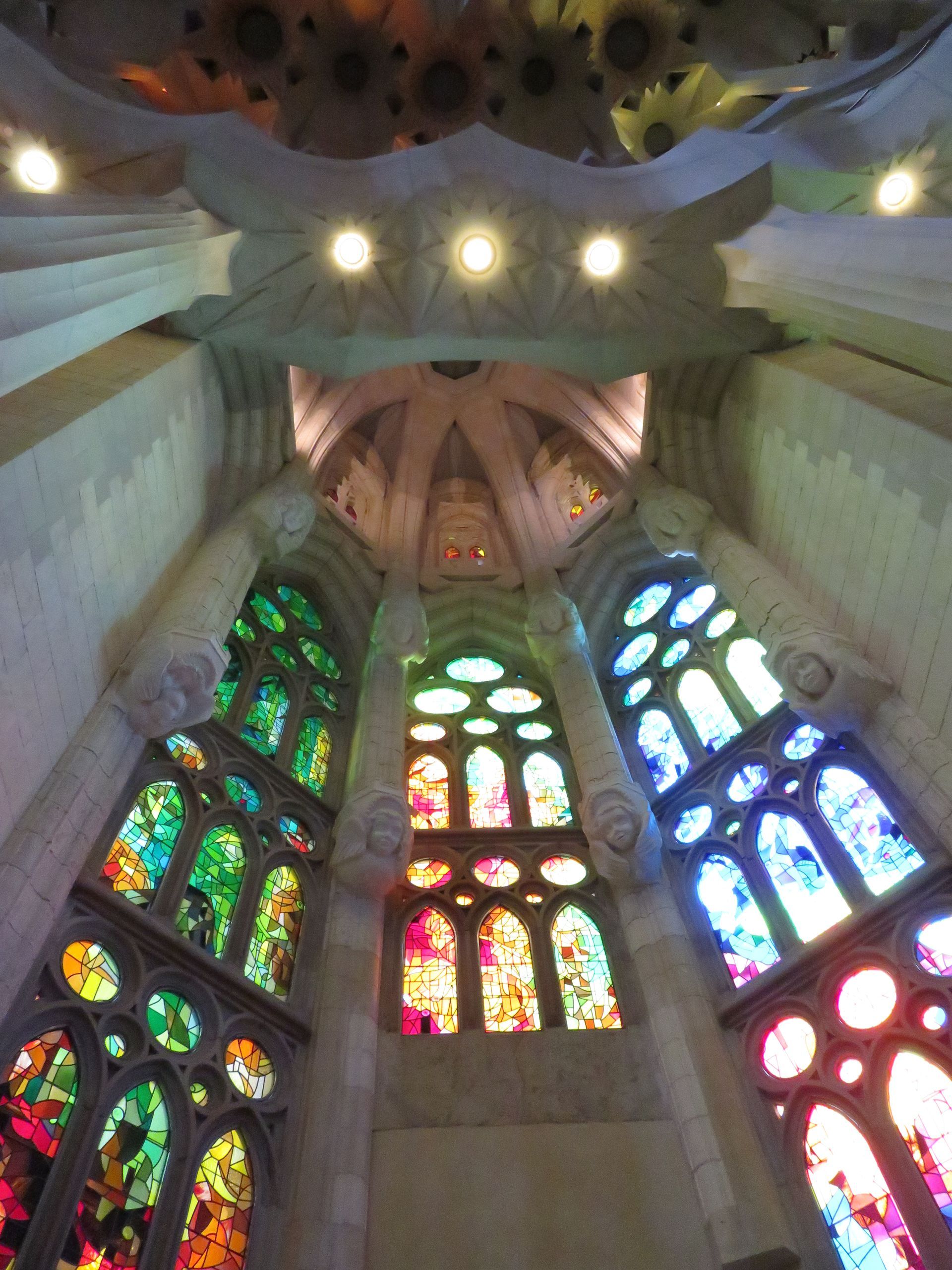 An airplane is flying over the ocean with mountains in the background.