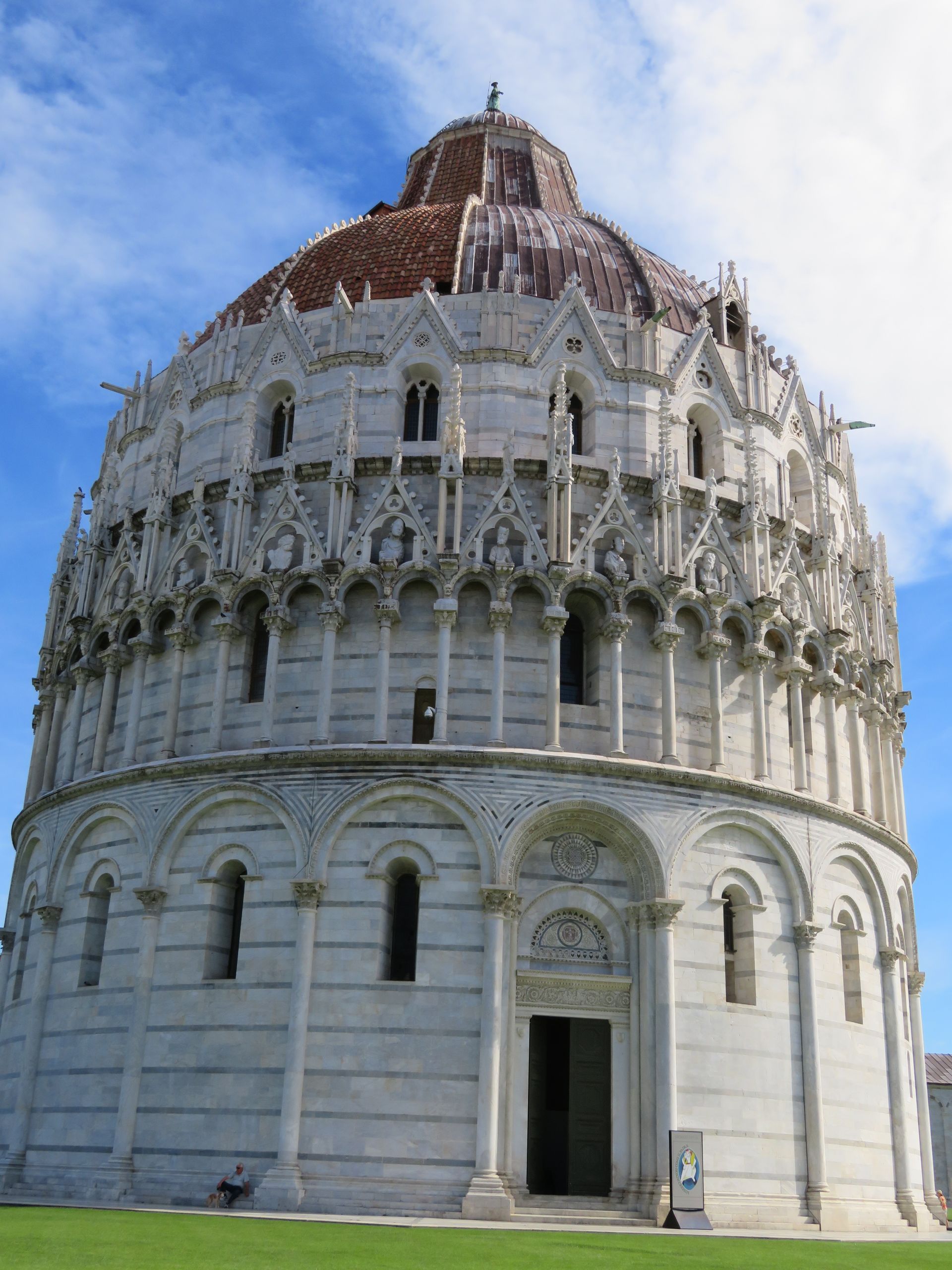 A person is standing on a wooden bridge over a river surrounded by trees.