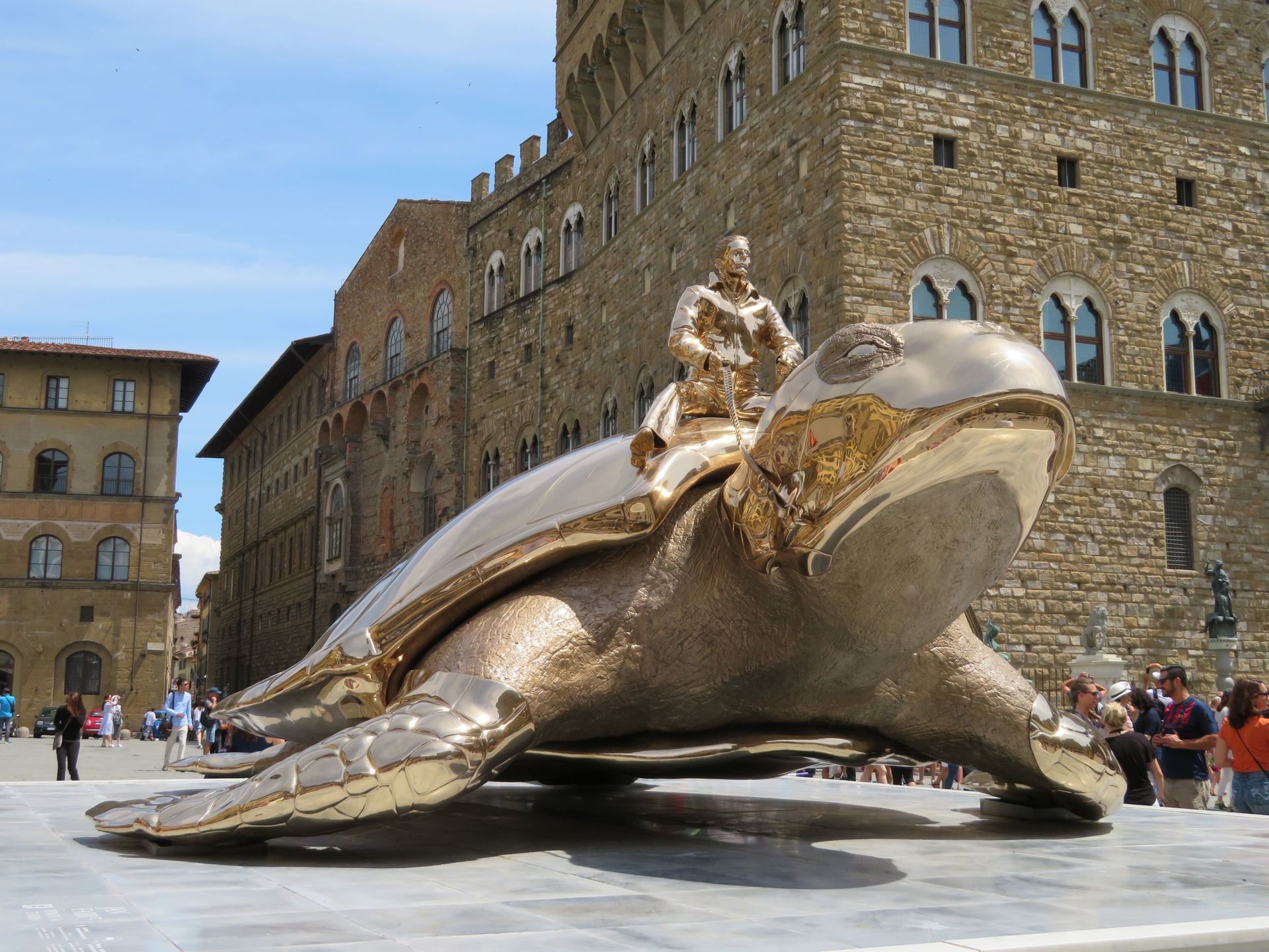 The statue of liberty is standing in front of the new york city skyline.