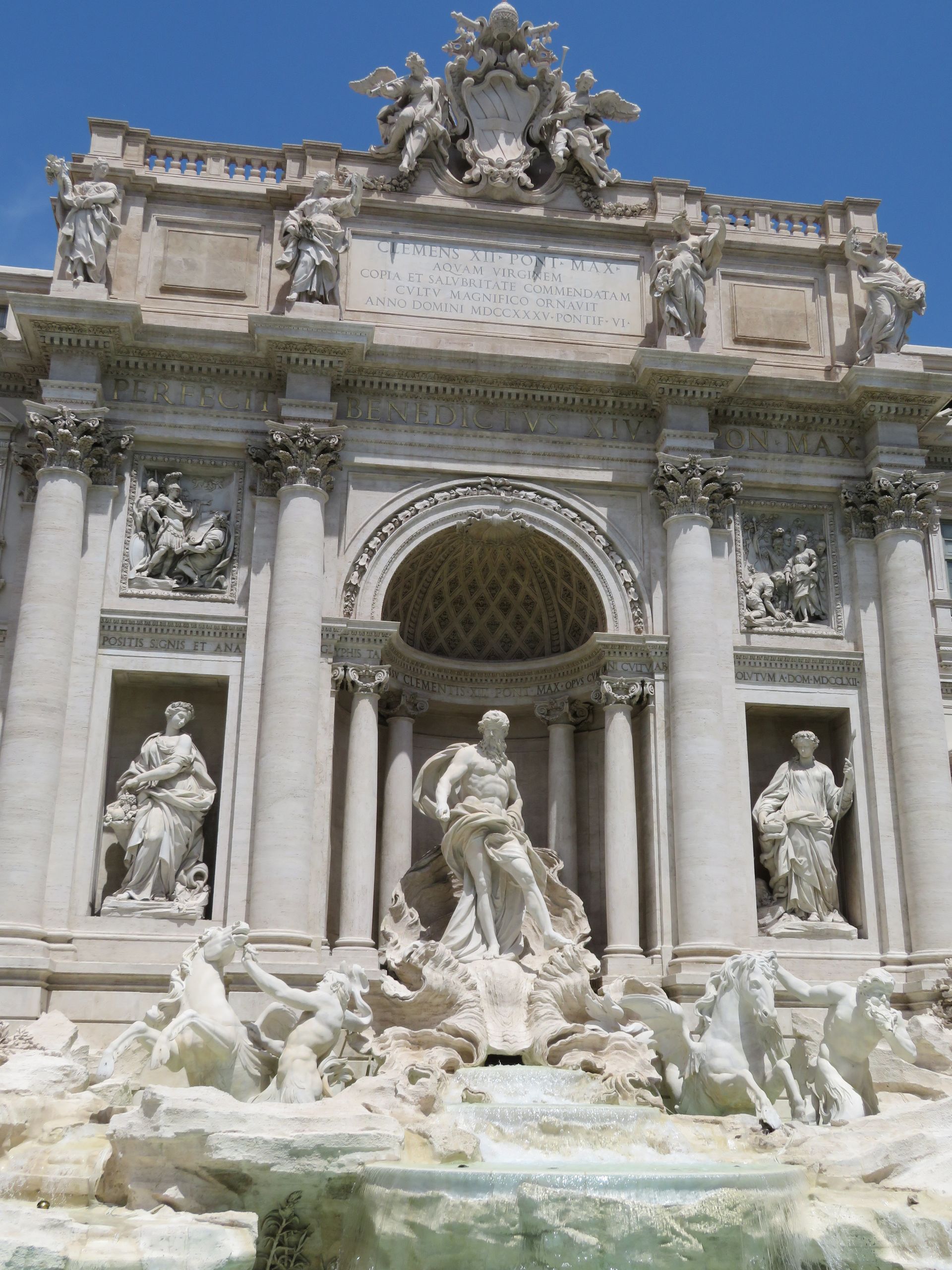 There are chairs and umbrellas on the beach near the water.