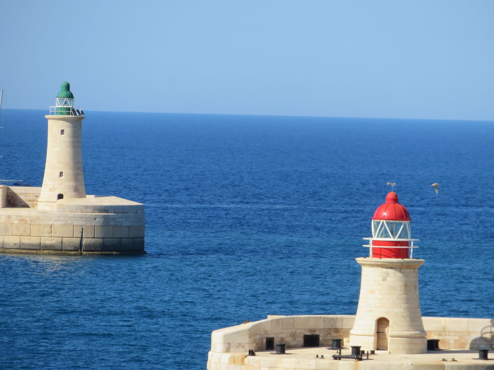 A beach chair is sitting on a sandy beach under a palm tree.