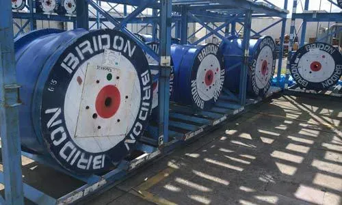 A bunch of spools of wire are sitting on a rack.