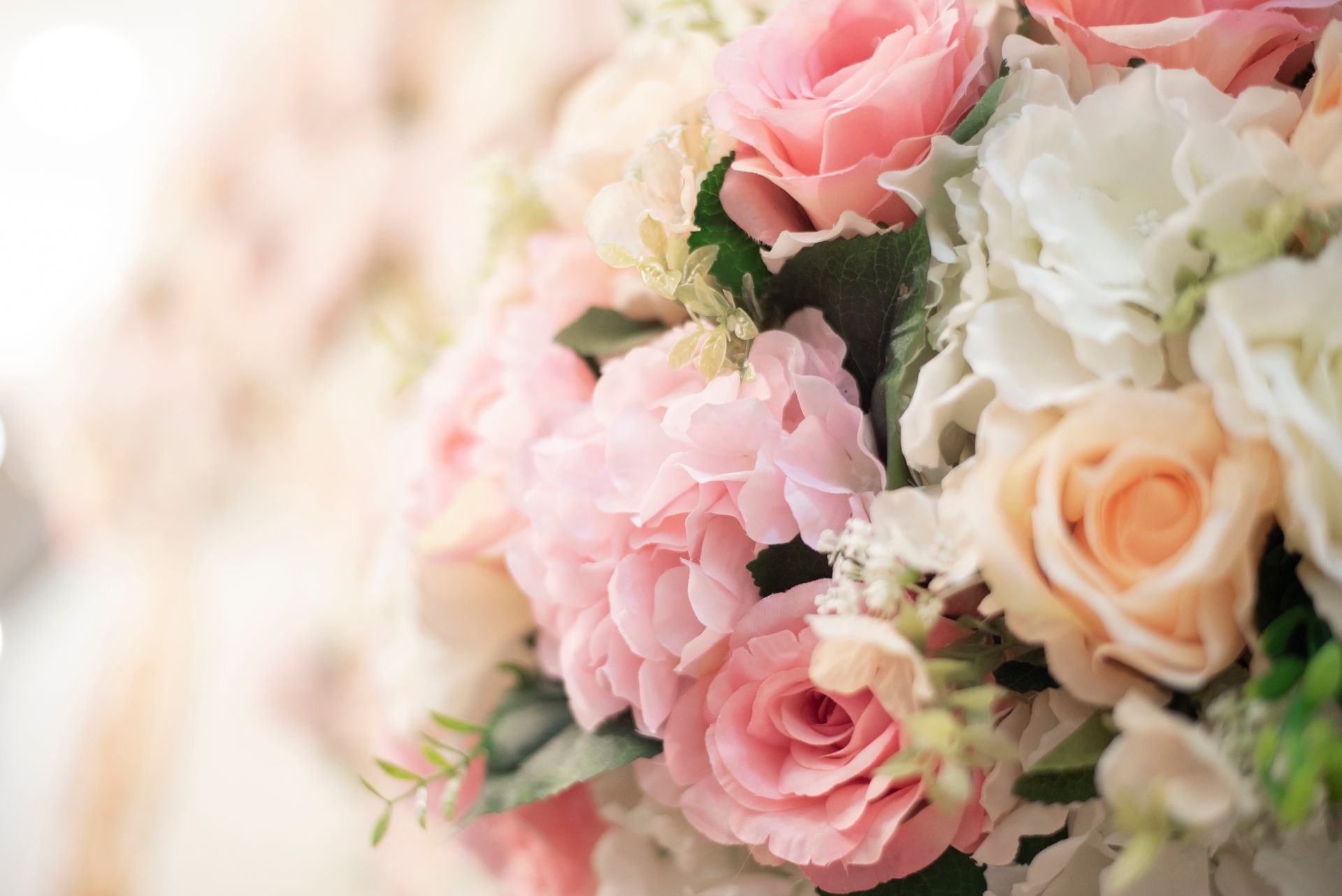 A close up of a bouquet of pink and white roses on a table.