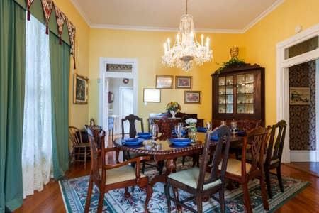 A dining room with a table and chairs and a chandelier.