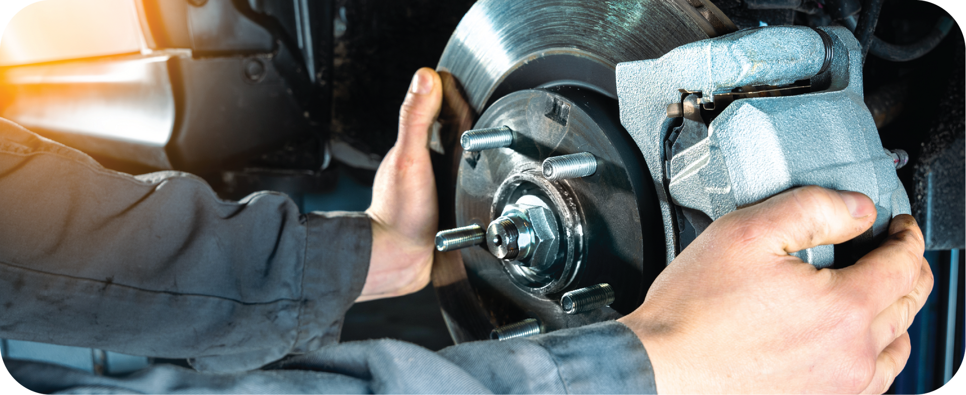 A man is fixing a brake on a car.