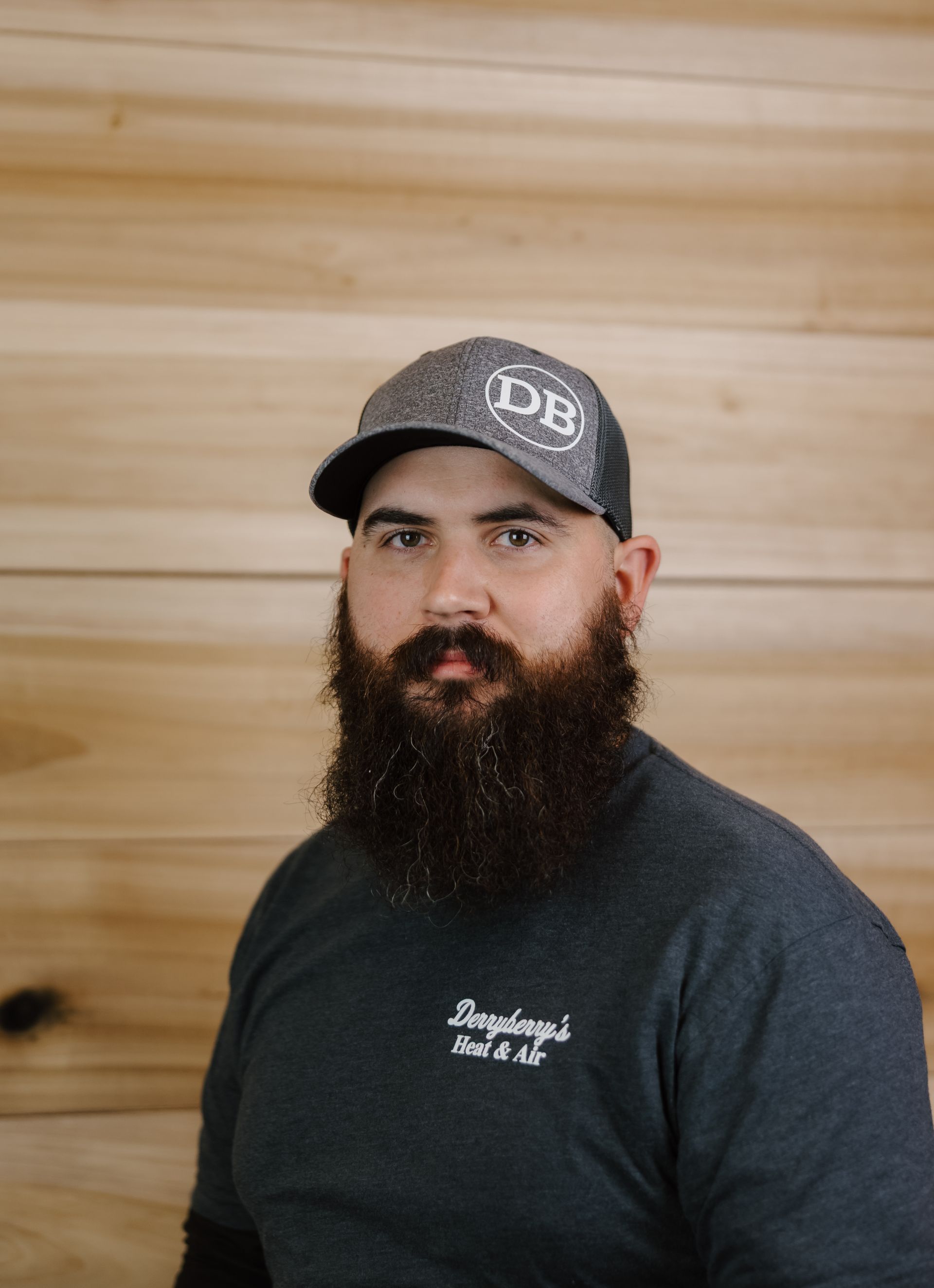 Man with a full beard wearing a baseball cap with 