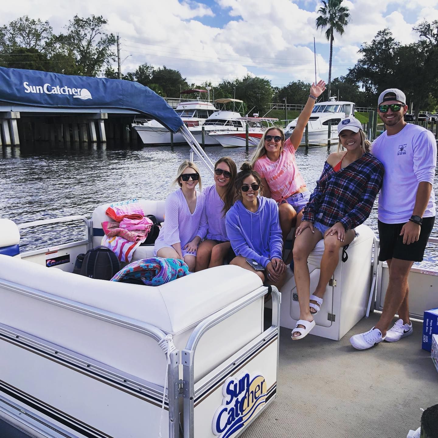 A group of people on a pontoon boat that says sun catcher
