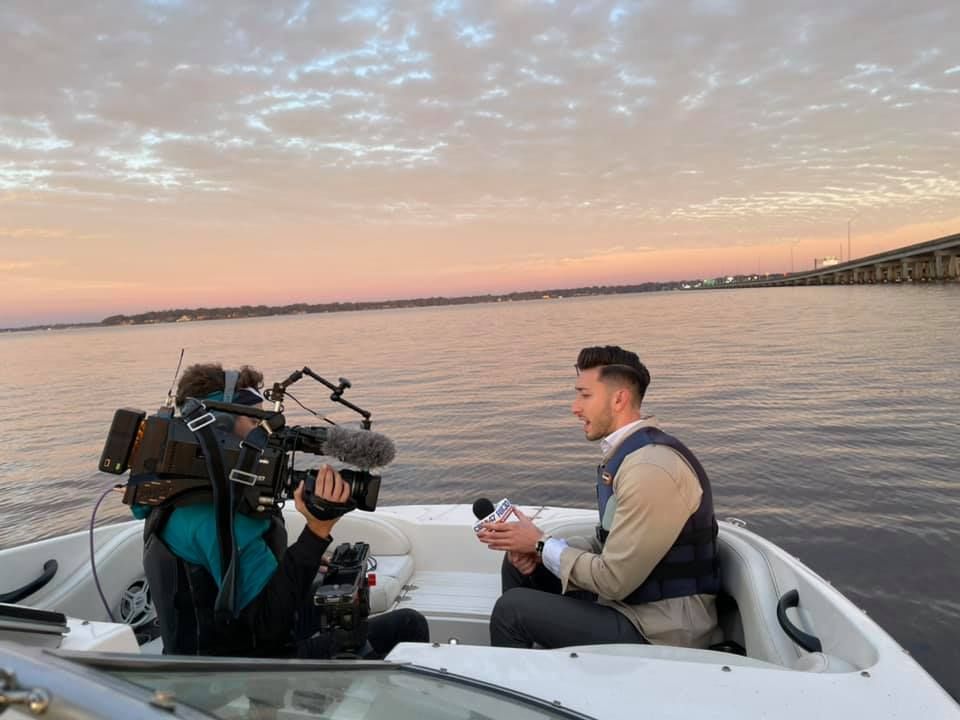 A man is sitting on a boat talking to a cameraman
