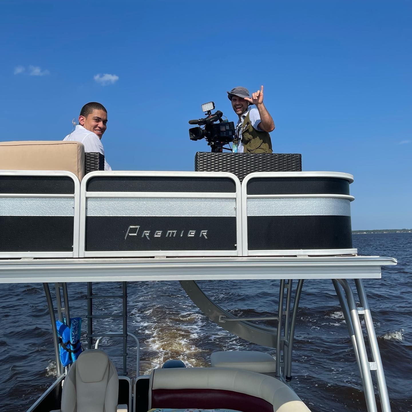 Two men on a pontoon boat with the word premier on the side
