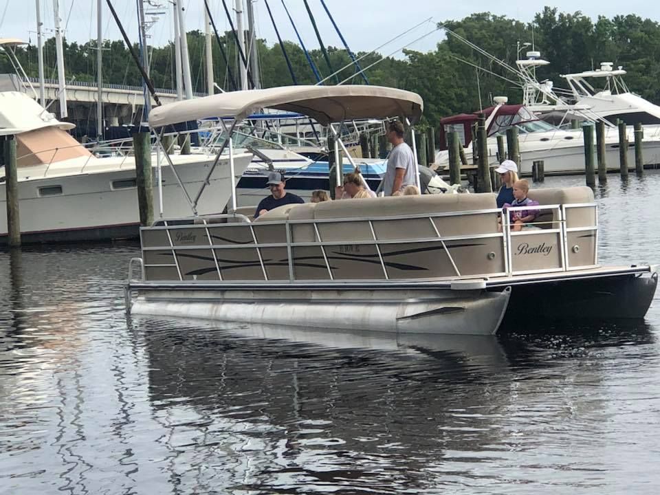 A pontoon boat is floating on a body of water.