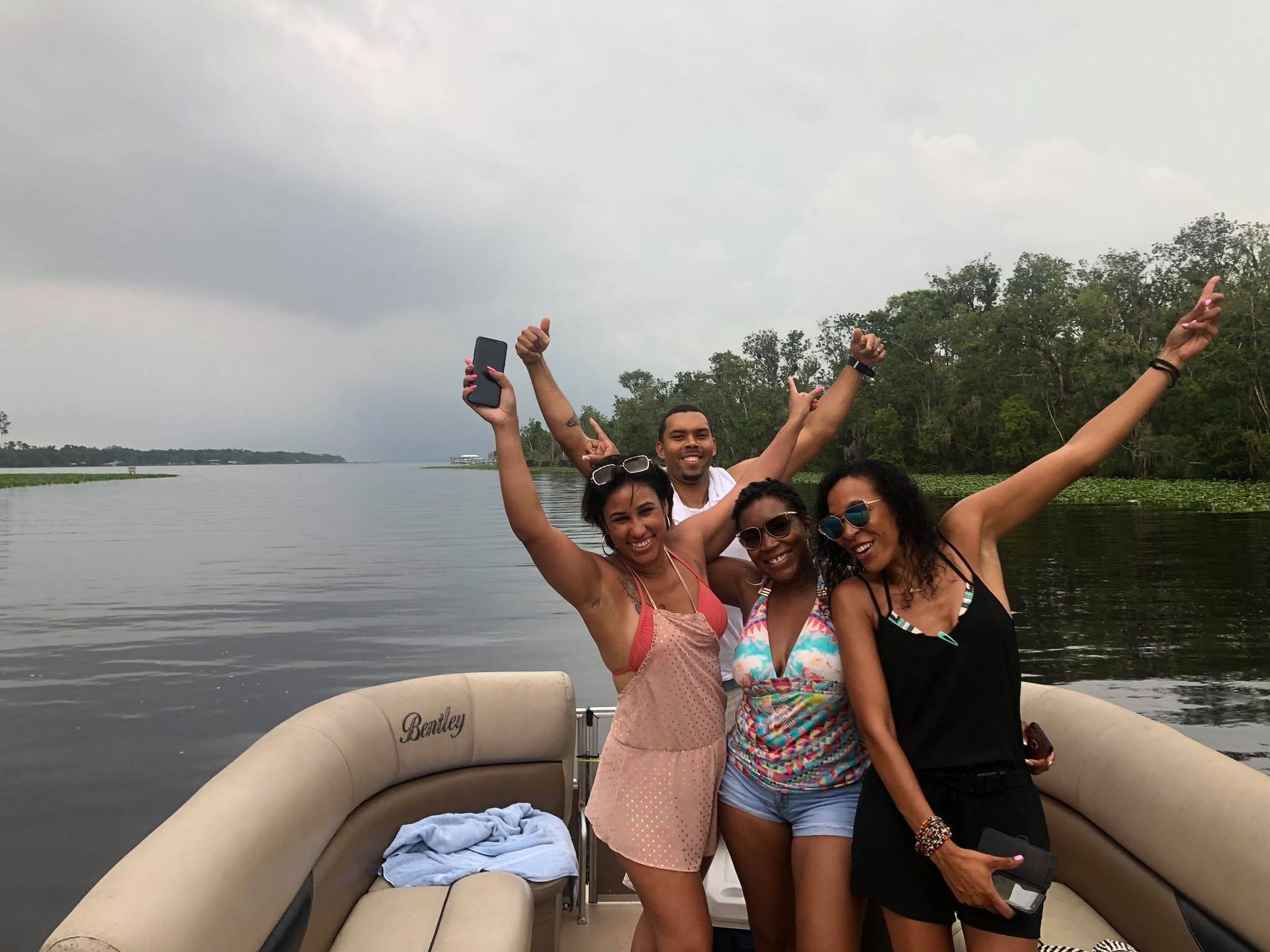 A group of people standing on a boat with their arms in the air