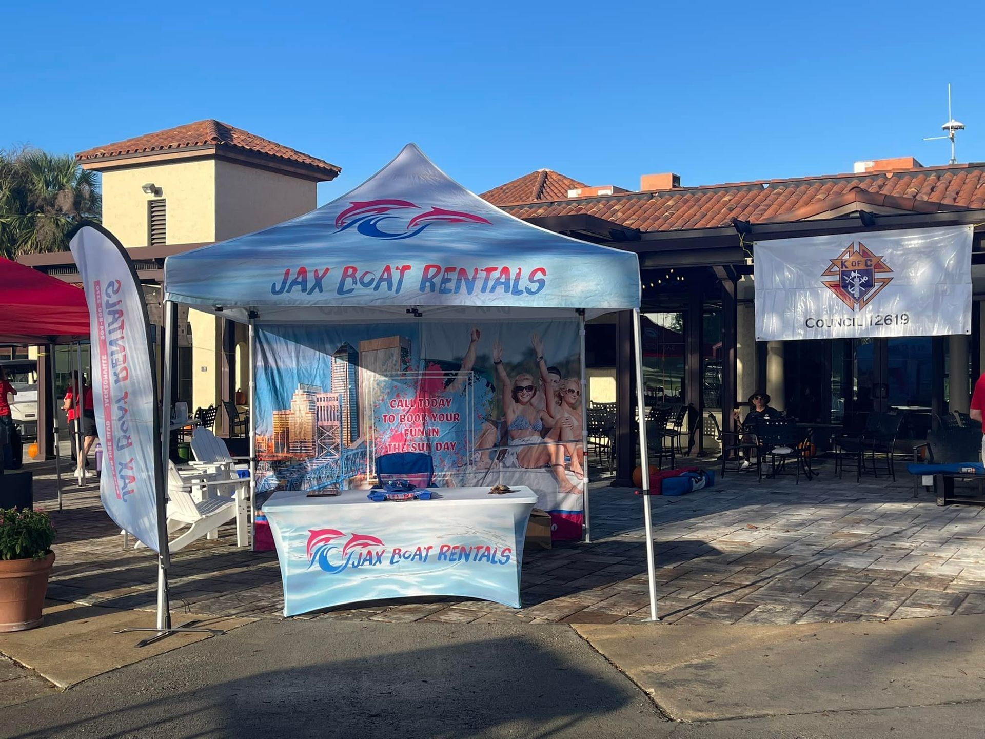 A tent for jax boat rentals is in front of a building