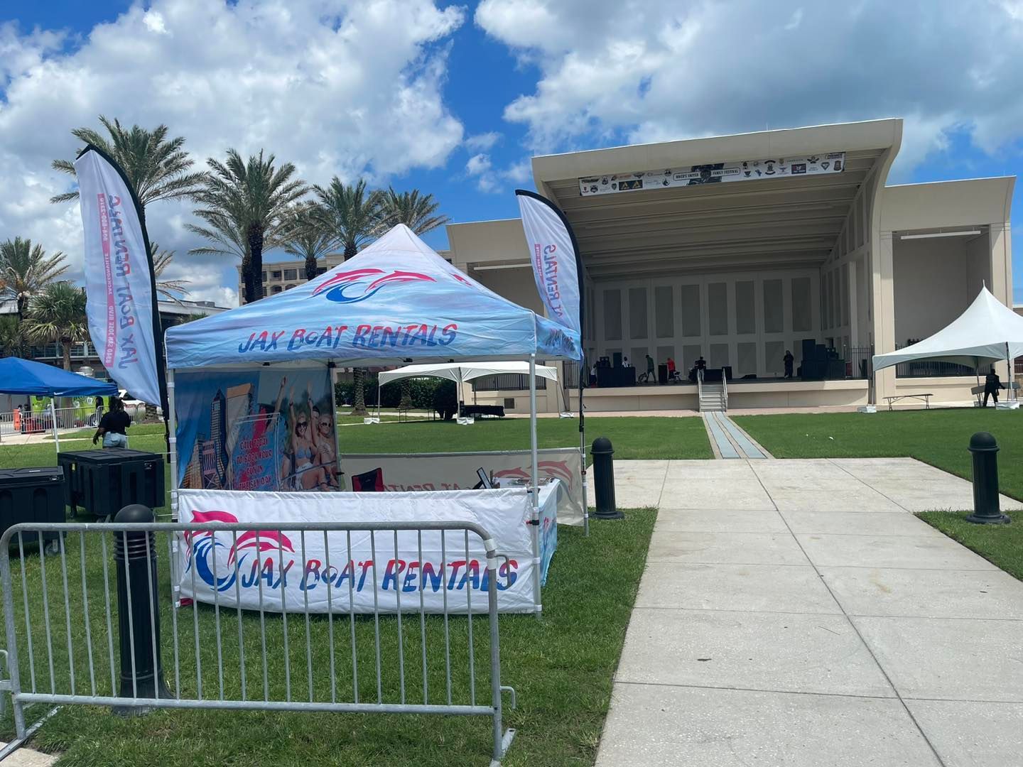 A tent with a sign that says jay boat rentals is sitting in front of a stage.