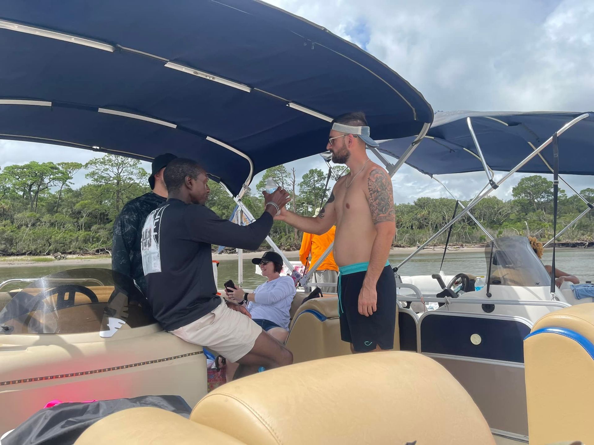 A group of men are sitting on a boat talking to each other.