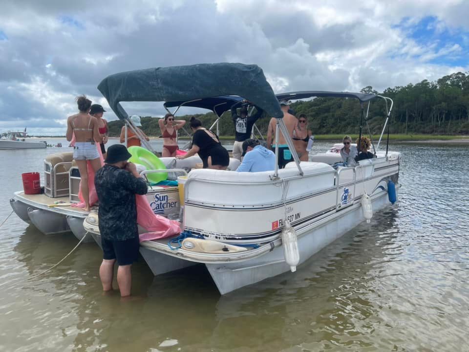 A group of people are standing on a boat in the water.