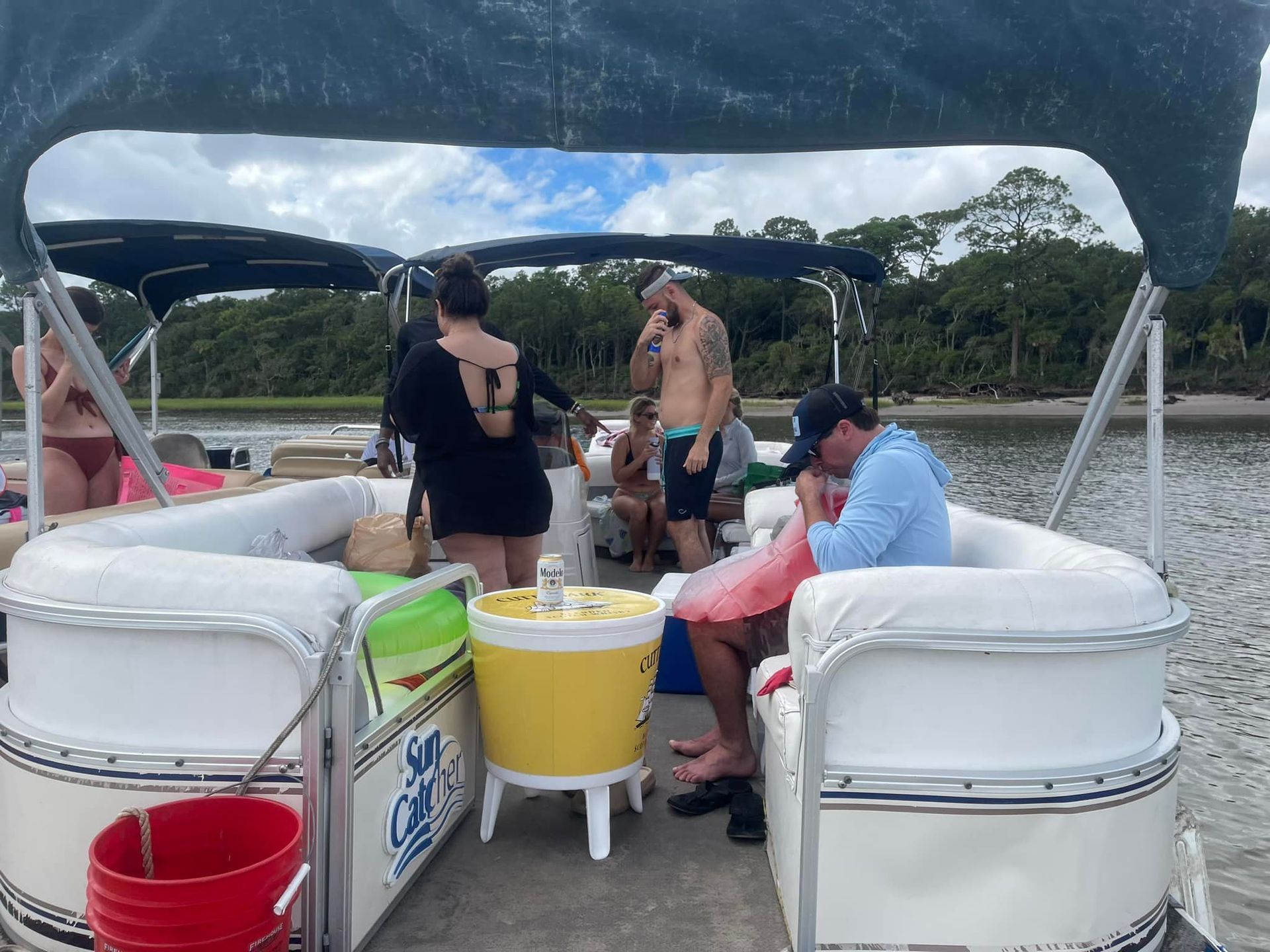A group of people are sitting on a pontoon boat.