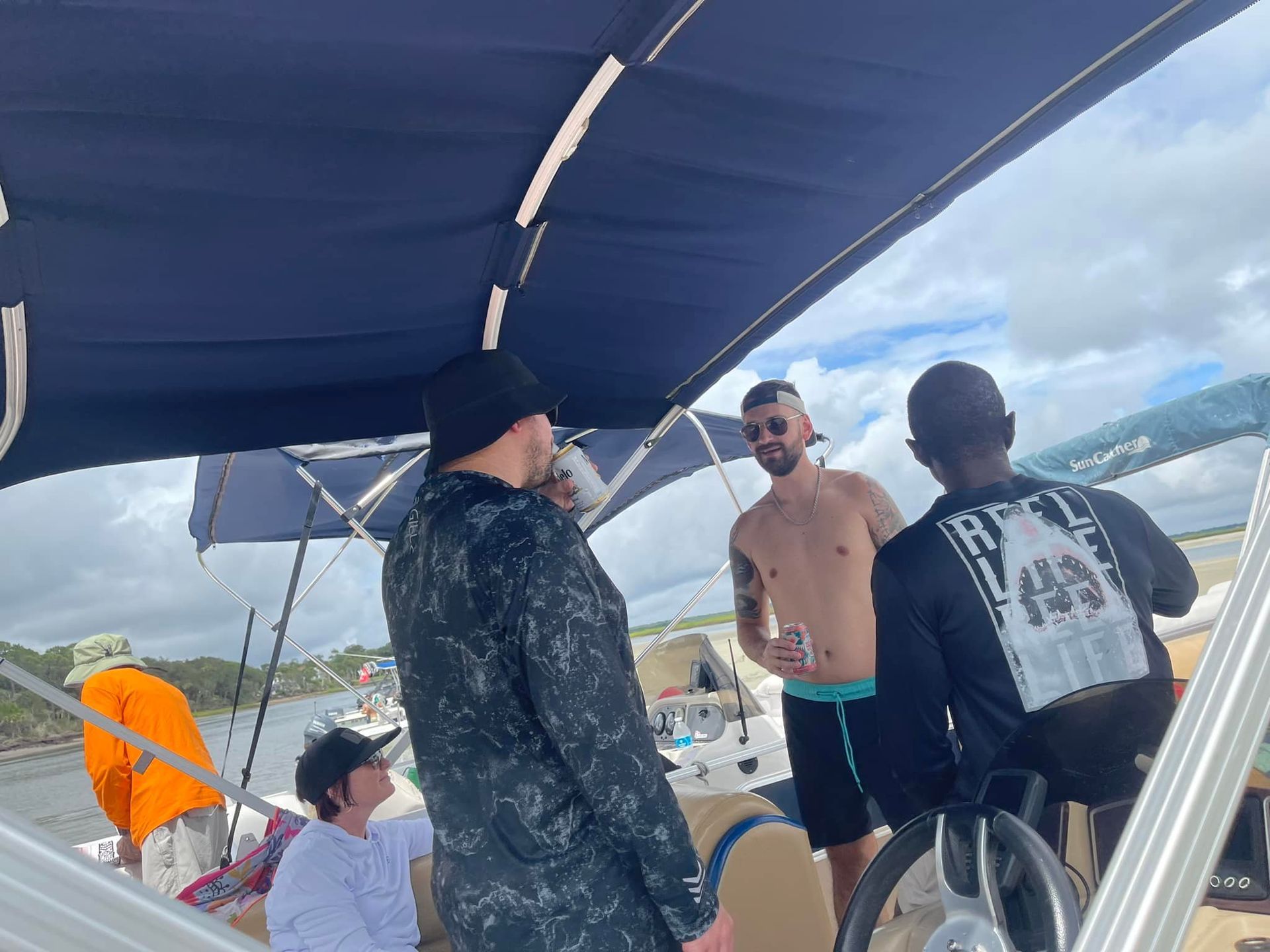 A group of men are standing on a boat talking to each other.